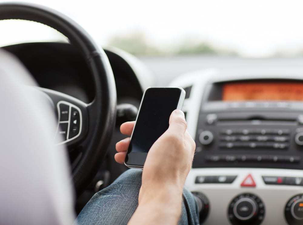 Close-up-of-driver-holding-a-cell-phone