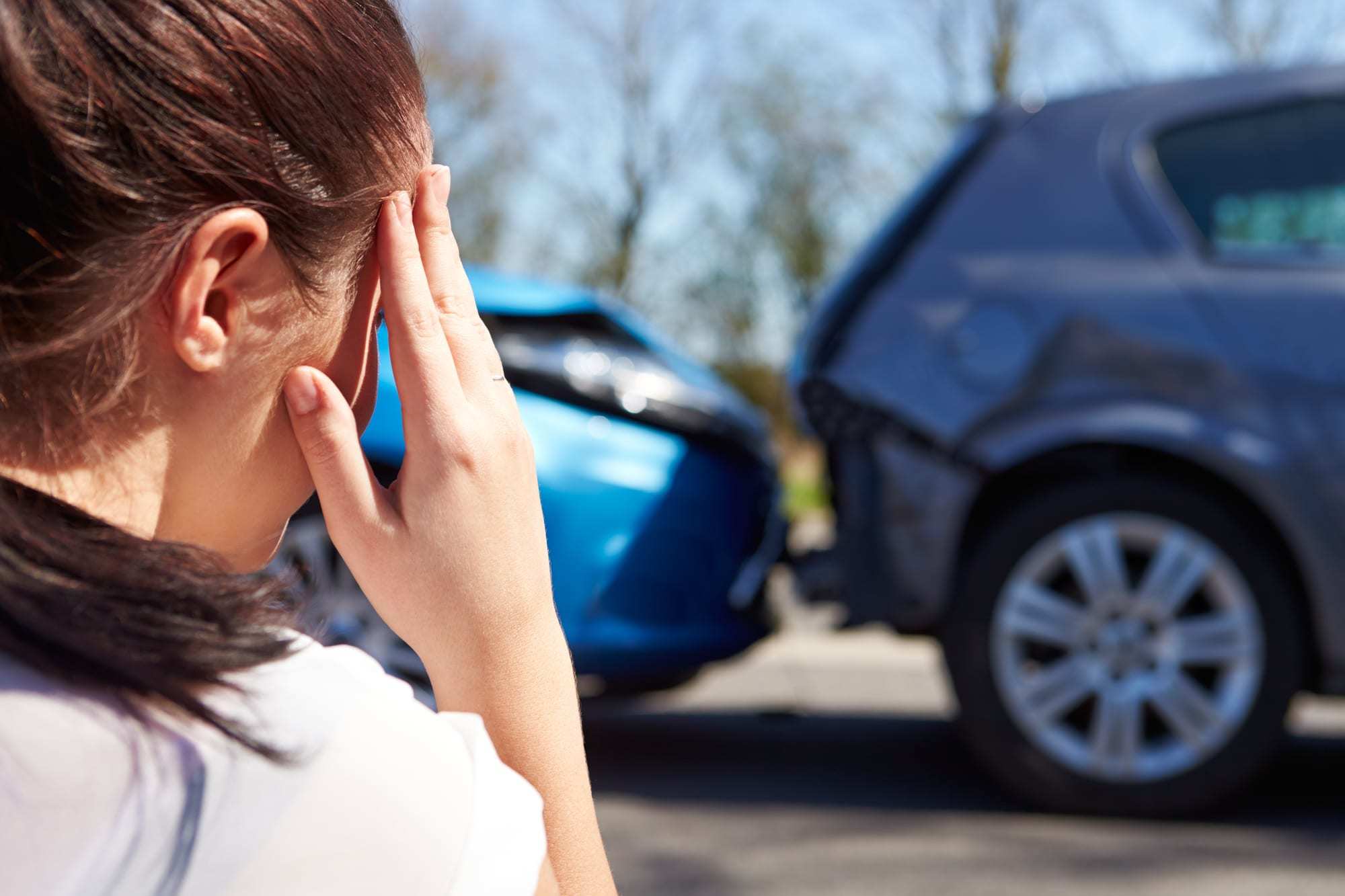 Stressed Young Woman Looking at Car Accident